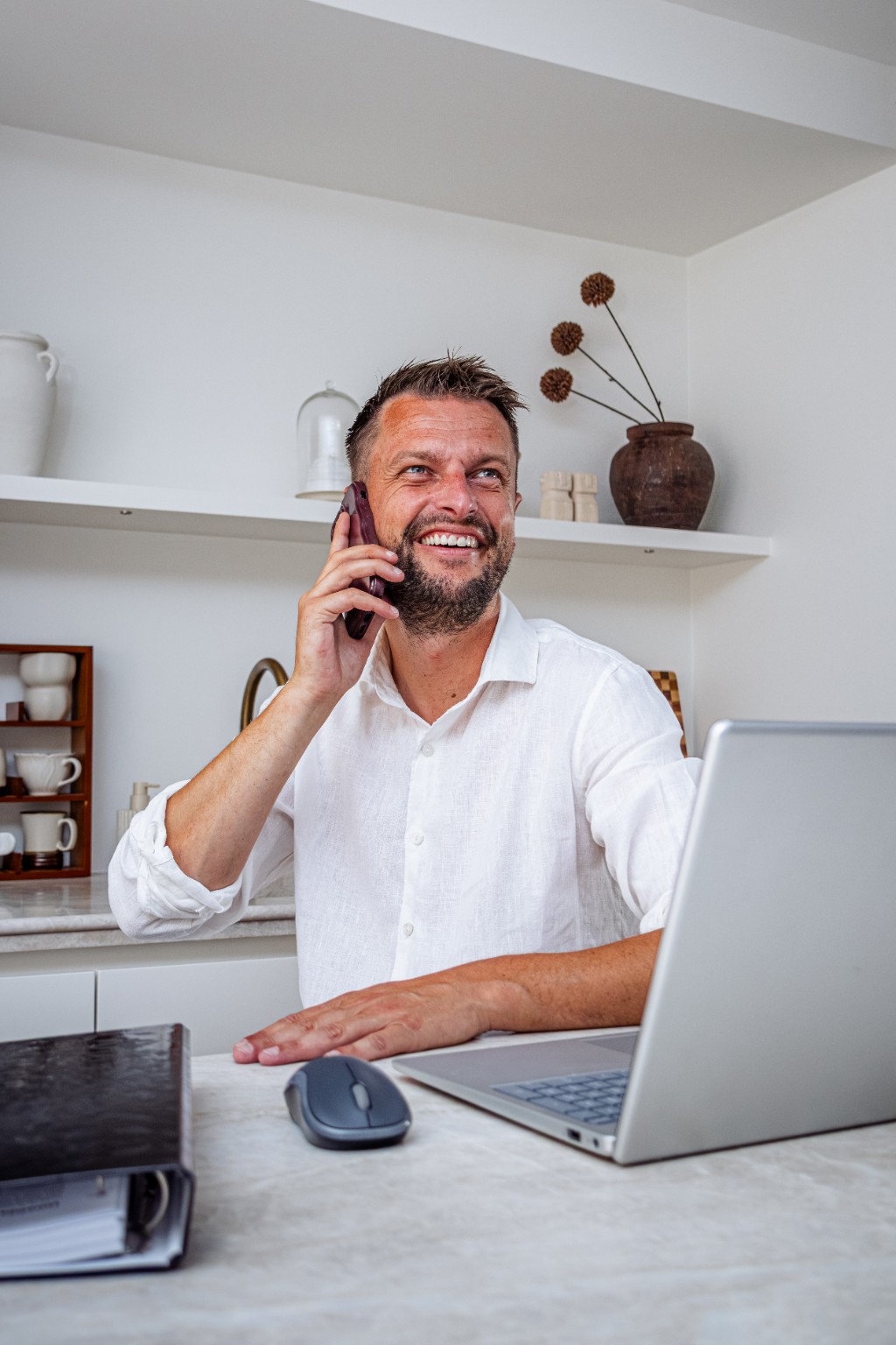 William Renes tijdens een telefoongesprek achter zijn laptop